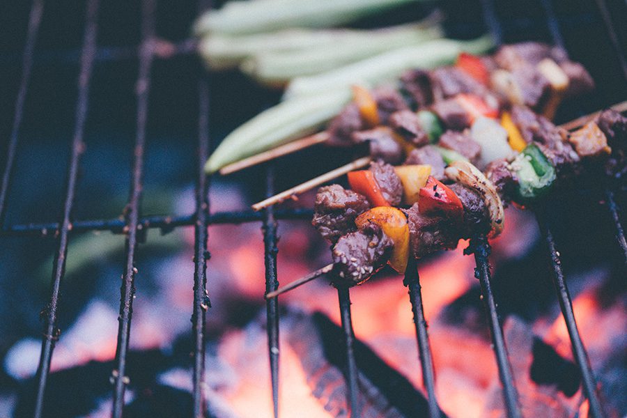 Premium Photo | A barbecue grill with meat on it and a fire in the  background.