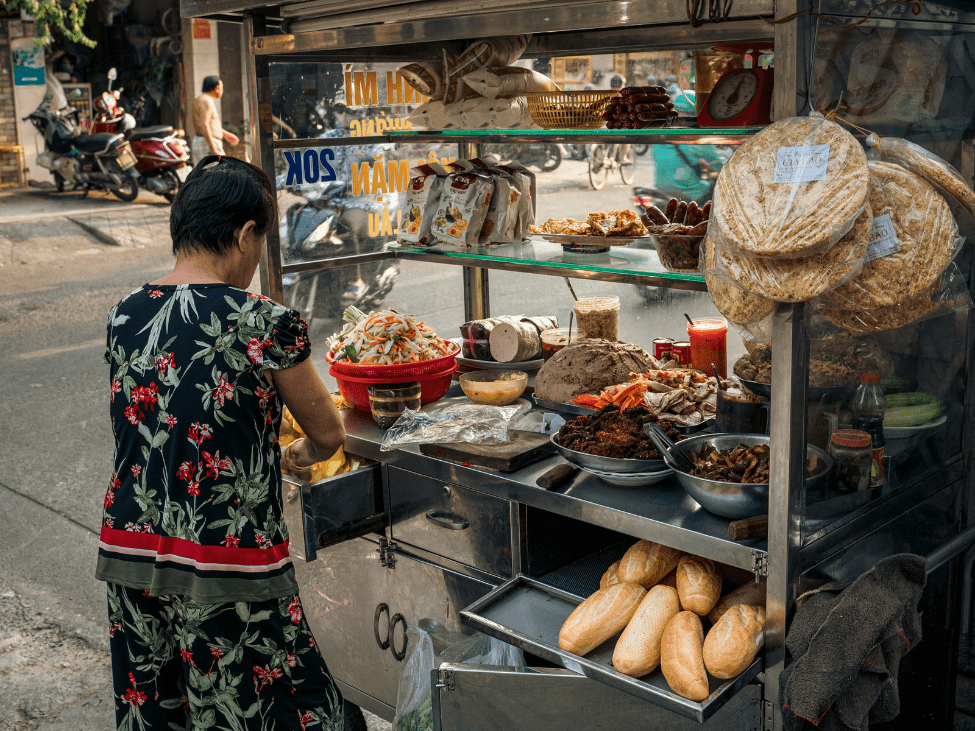Vendor preparing fresh Bánh Mì at Binh Tay Market.