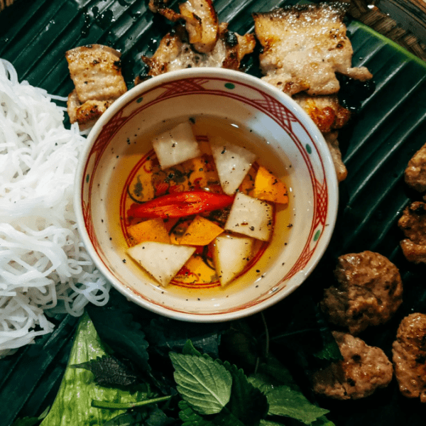 Bun Cha, a popular Hanoi street food, featuring grilled pork patties and vermicelli noodles.