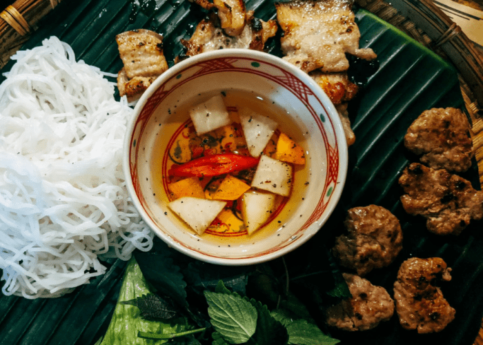 Bun Cha, a popular Hanoi street food, featuring grilled pork patties and vermicelli noodles.