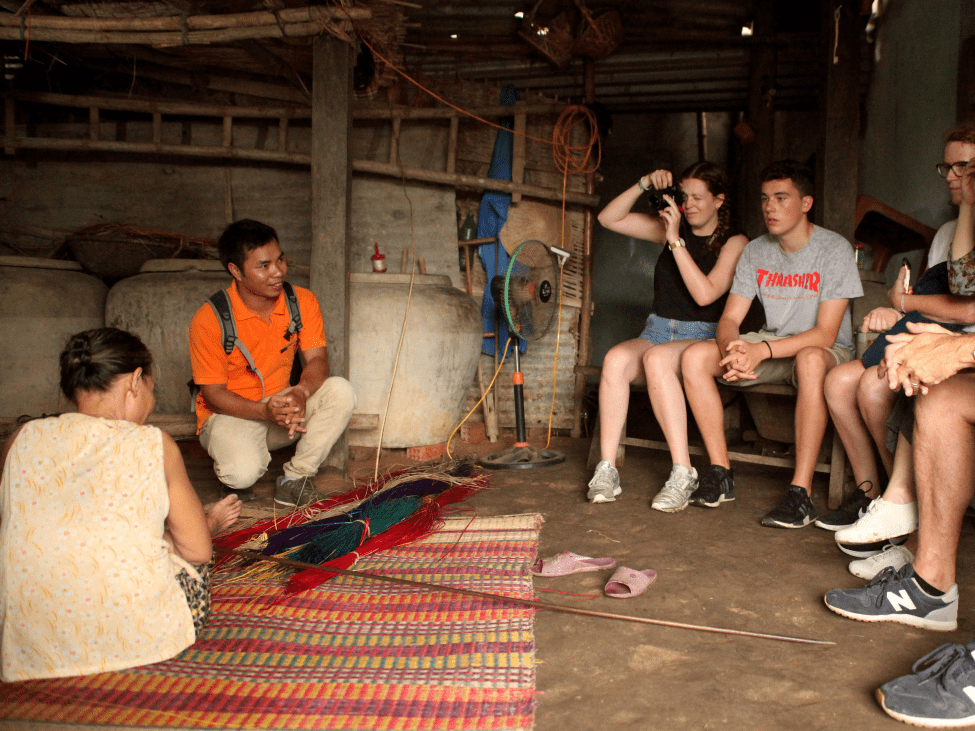 Travelers chatting with local Vietnamese people during a tour.