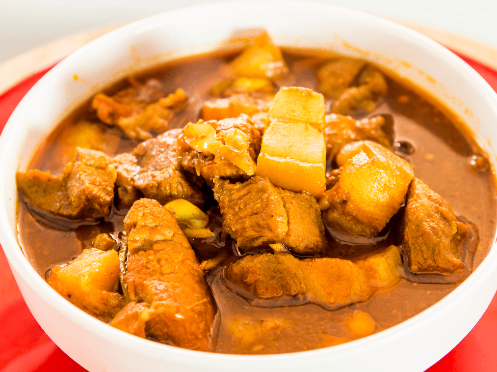 Burmese-style pork curry, Gaeng Hang Lay, rich in spices and served with steamed rice.