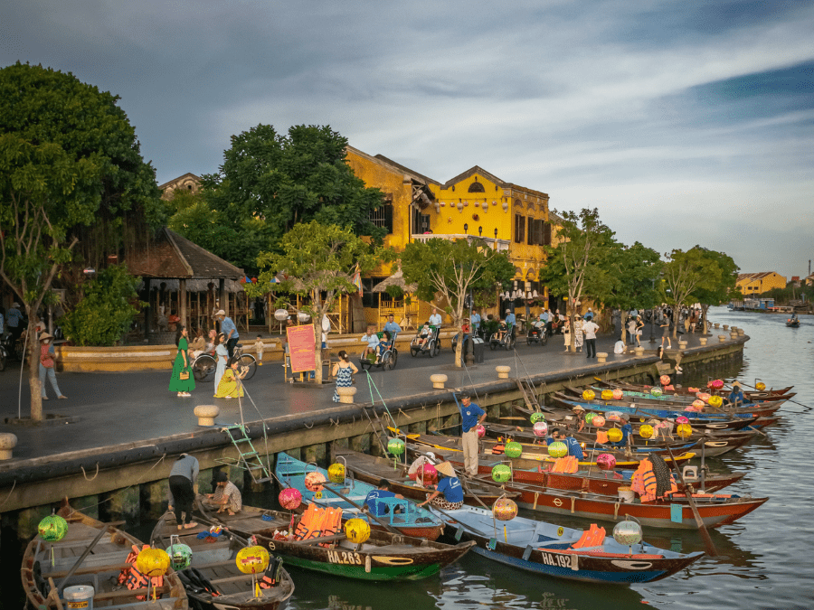 Picturesque view of the Thu Bon River with traditional boats and riverside villages in Hoi An.