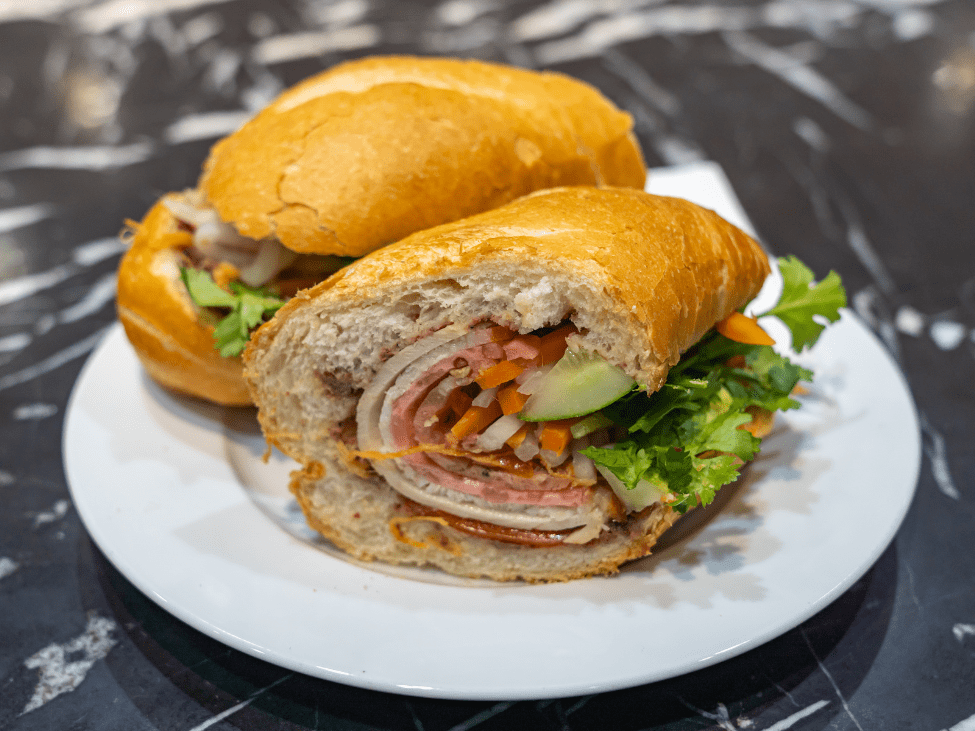 A crispy banh mi sandwich filled with pate, grilled pork, and fresh vegetables