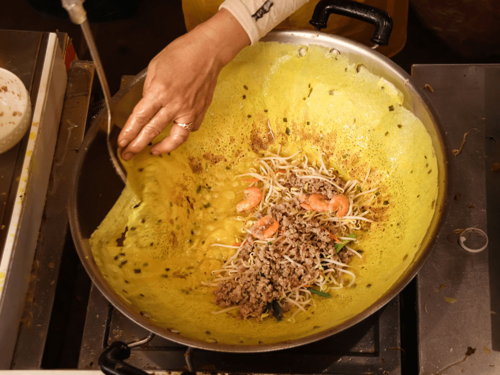 A crispy Banh Xeo pancake filled with shrimp and bean sprouts