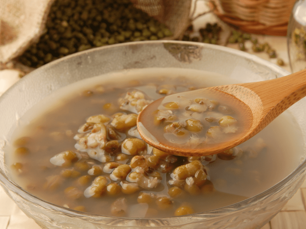 A bowl of Chè Đậu Xanh, a sweet mung bean soup, served with coconut milk.