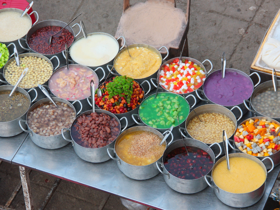 A bowl of Che with beans, fruits, and coconut milk