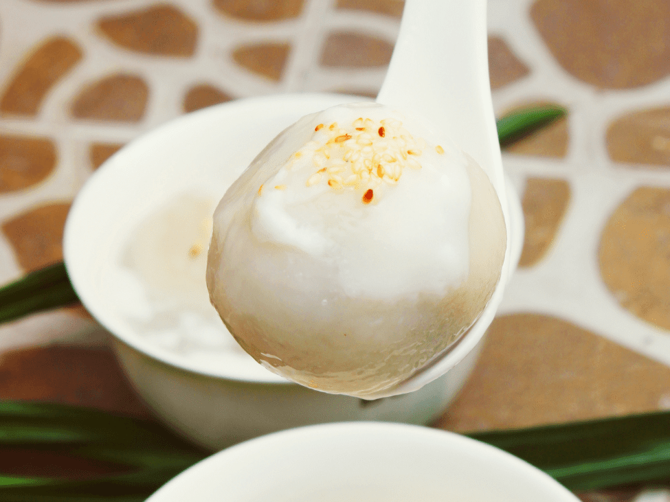 A bowl of Chè Trôi Nước with glutinous rice dumplings in ginger syrup.