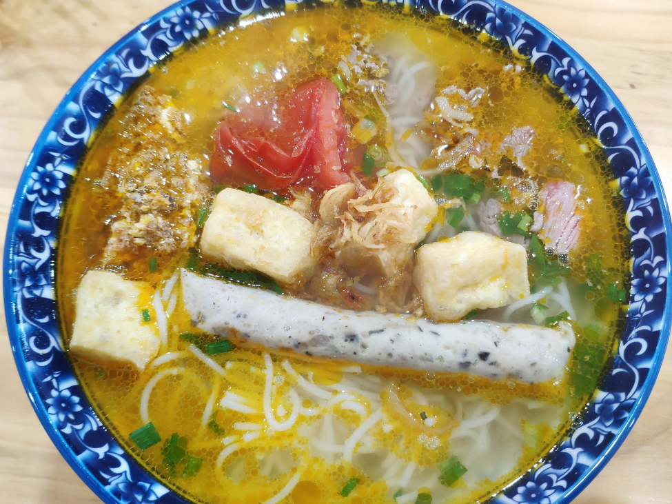 Miss Di Hai serving noodle soup on her boat at Cai Rang Floating Market.