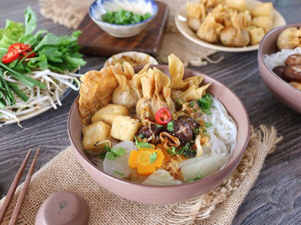 A vibrant bowl of vegetarian pho with fresh herbs in Vietnam