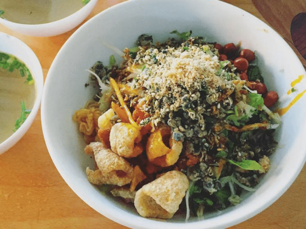 Com Hen rice dish topped with clams, herbs, and peanuts.