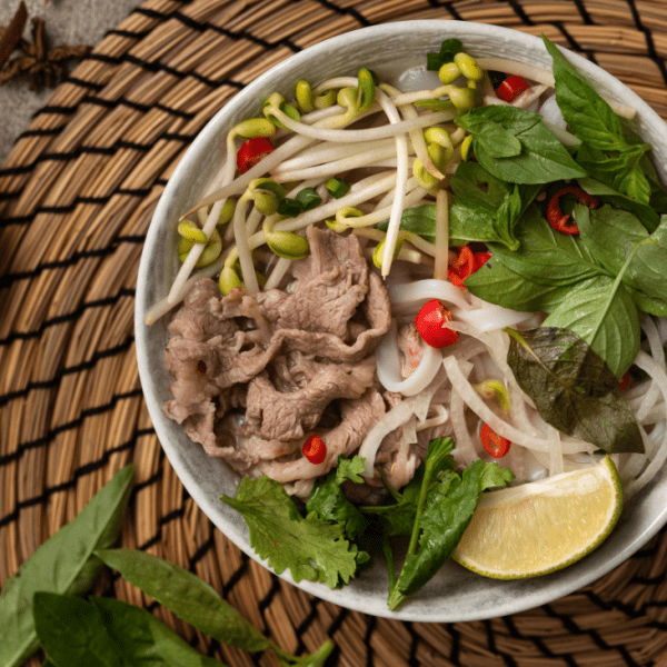 A steaming bowl of pho Vietnamese soup at Pho Thin Tokyo, showcasing Hanoi-style broth and fresh herbs.