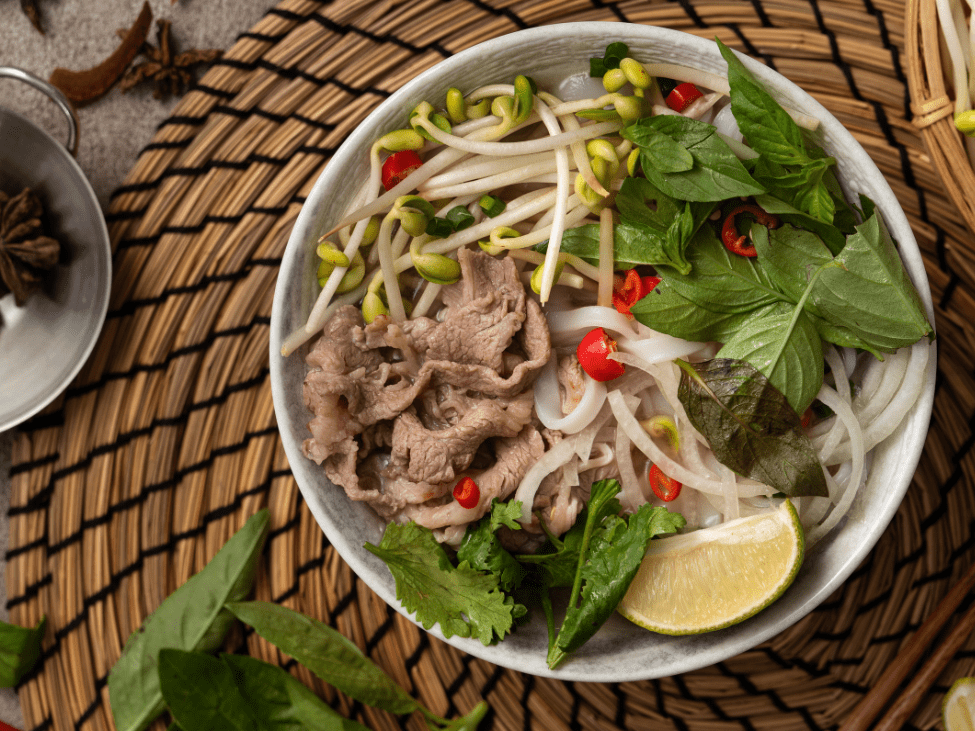 A steaming bowl of pho Vietnamese soup at Pho Thin Tokyo, showcasing Hanoi-style broth and fresh herbs.