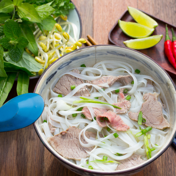 A steaming bowl of pho viet with fresh herbs and noodles, served at Superior Pho.