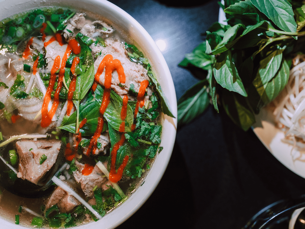 A cozy bowl of comforting pho with fresh herbs at Pho Vui in Hanoi's Hang Giay street.