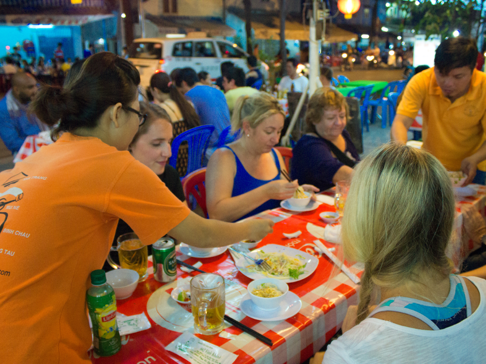 Travelers enjoyed Vietnamese food on the streets of Saigon, part of the Saigon Foodie Experience tour.