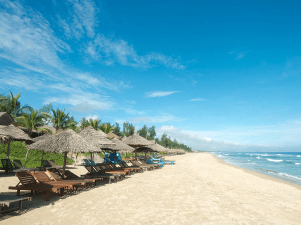 Serene view of An Bang Beach with clear waters and golden sands. 