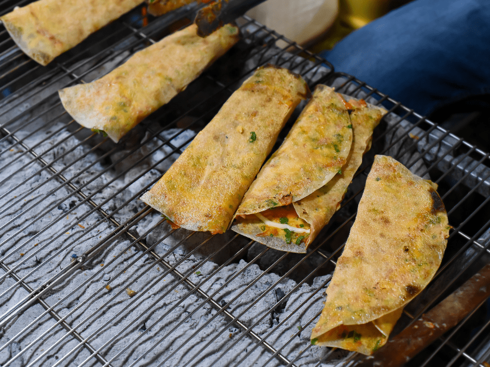 Crispy Banh Trang Nuong, also known as Vietnamese pizza, being prepared in Ho Chi Minh City.