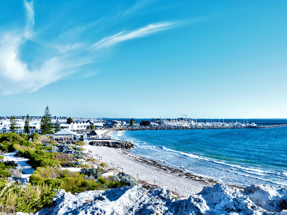 A scenic view of Fremantle Harbor with boats docked and a clear blue sky.