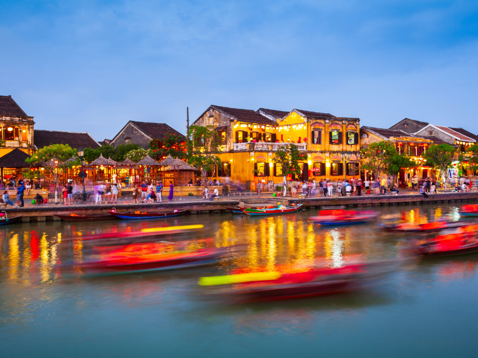 People celebrating the full moon festival in Hoi An with colorful lanterns and traditional dress.