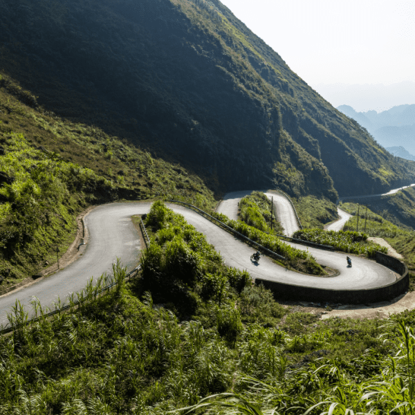 Scenic viewpoint along the Ha Giang Loop showcasing lush valleys and dramatic limestone mountains.