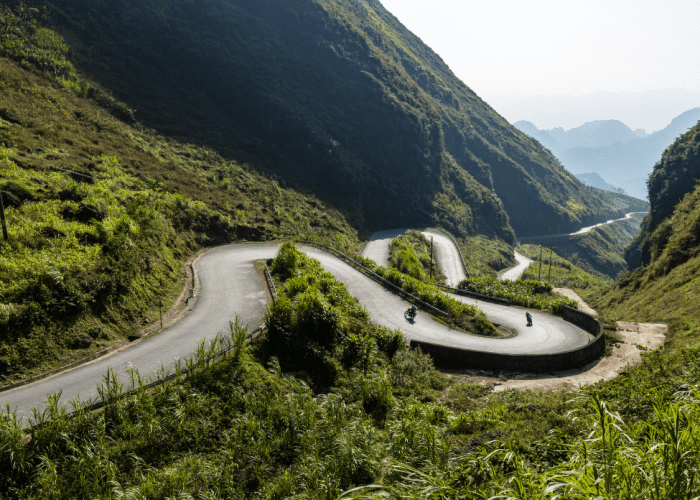 Scenic viewpoint along the Ha Giang Loop showcasing lush valleys and dramatic limestone mountains.