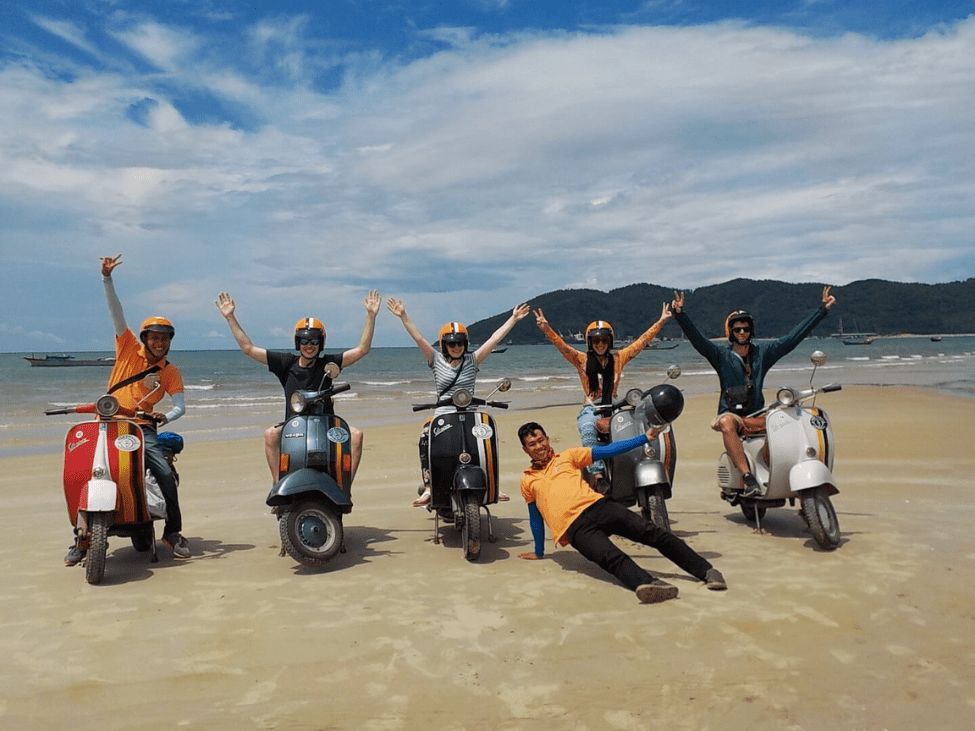 Travelers enjoying a scenic Vespa ride along the Hai Van Pass during the Hoi An to Hue Coastal Adventure.