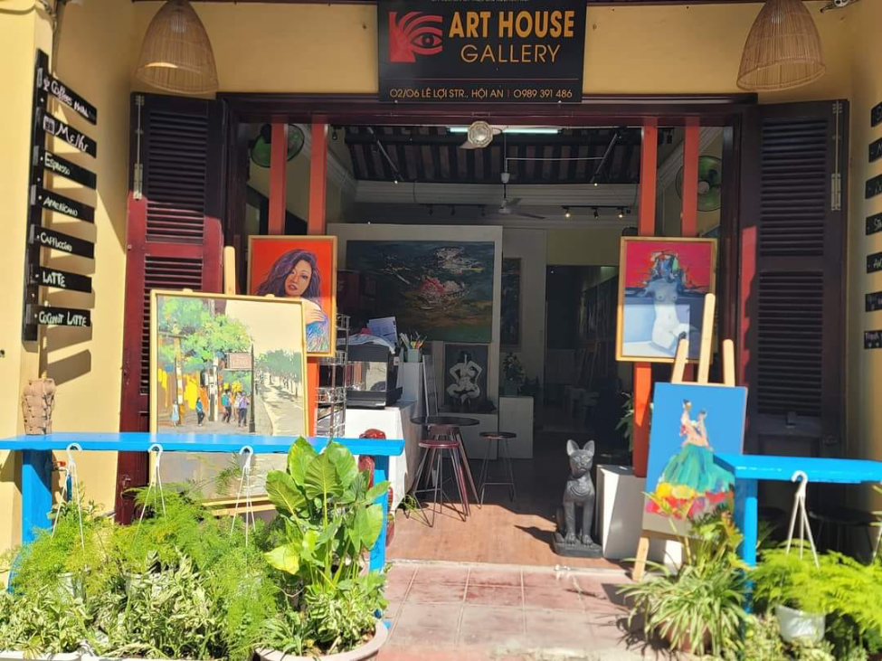 An artist working on a traditional Vietnamese painting in a Hoi An art studio.