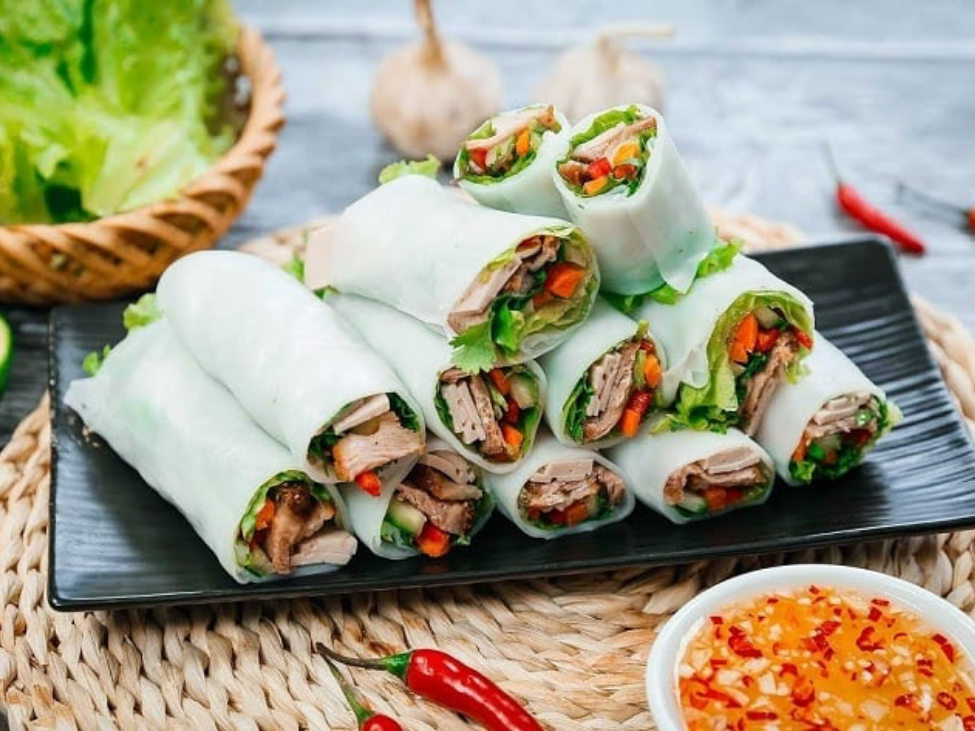 A plate of pho cuon from Hương Mai in Hanoi, featuring tender beef and fresh herbs.