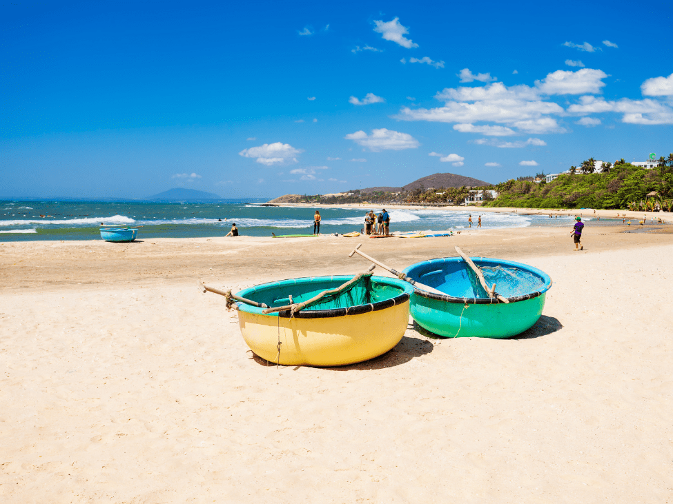 Mui Ne Beach with windsurfers enjoying the waves and scenic sand dunes.