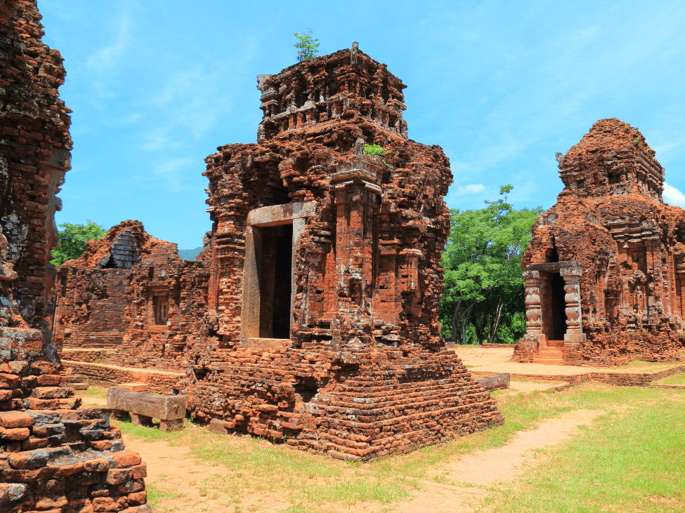 Ancient Hindu temples of My Son Sanctuary surrounded by green foliage.