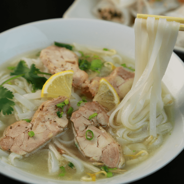 : A comparison of Pho Bo (beef) and Pho Ga (chicken) with traditional Vietnamese garnishes.