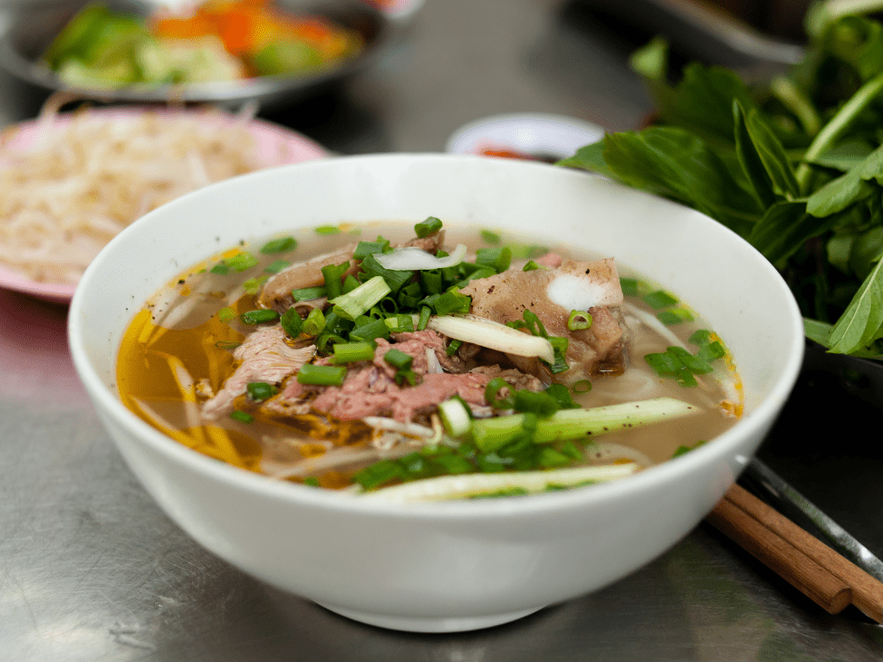 A bowl of traditional pho served at Phở Hòa Pasteur in Saigon, showcasing the rich flavors of Vietnamese pho.