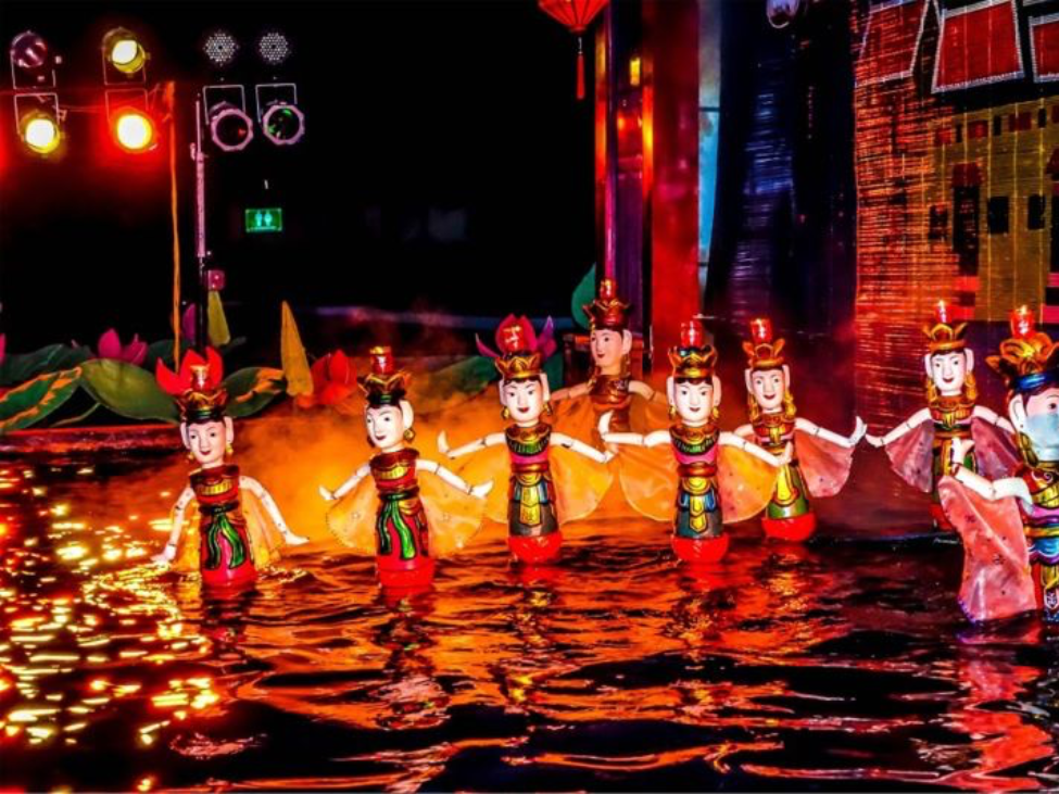 Puppeteers performing behind the screen during a water puppet show in Hanoi.