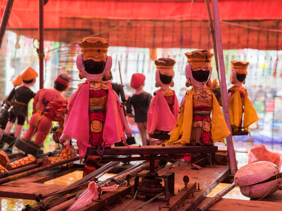 Colorful wooden puppets used in traditional water puppetry performances in Vietnam.