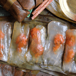 Banh bot loc wrapped in banana leaves with a visible shrimp and pork filling 