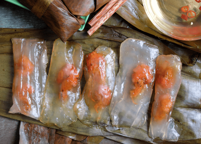 Banh bot loc wrapped in banana leaves with a visible shrimp and pork filling 