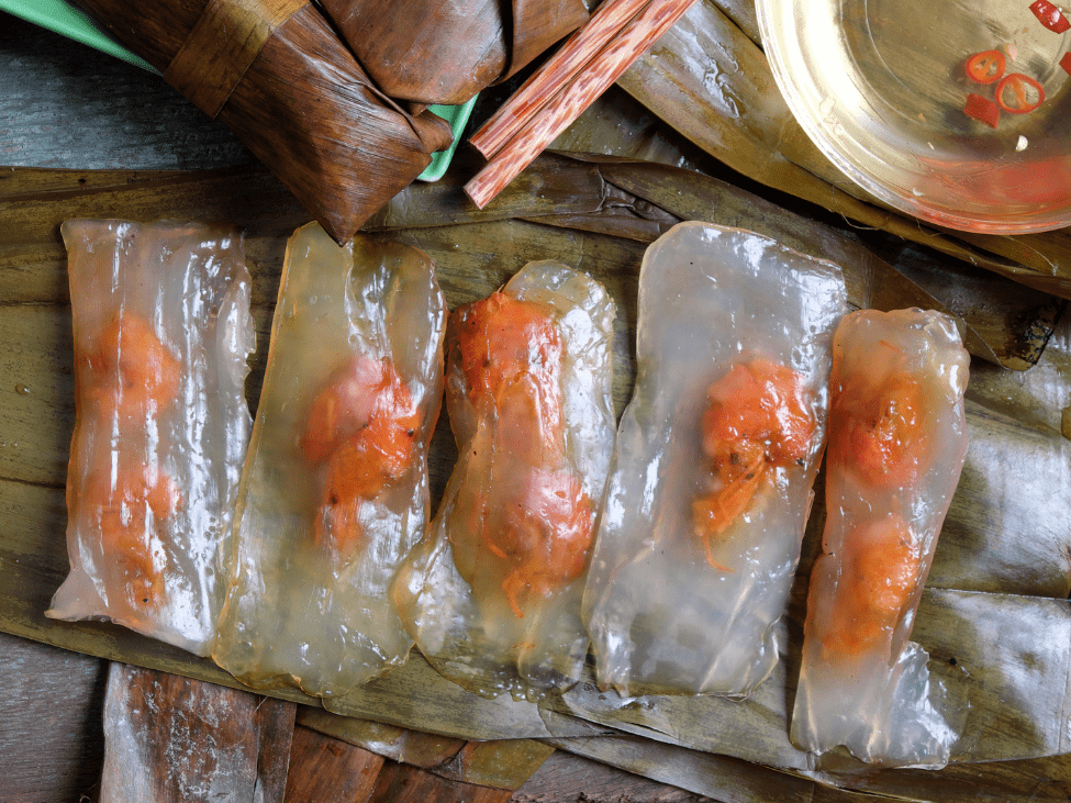 Banh bot loc wrapped in banana leaves with a visible shrimp and pork filling