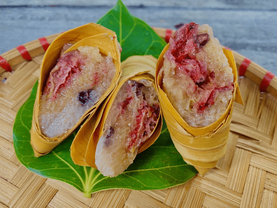 Banh la dua wrapped in banana leaves with vibrant green sticky rice