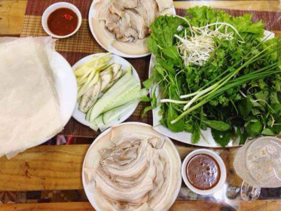 Banh Trang Cuon Thit Heo with pork slices and fresh herbs wrapped in rice paper