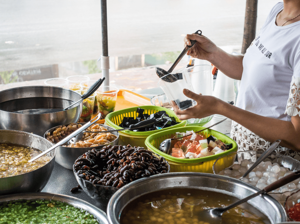 A bowl of colorful Vietnamese Chè with coconut milk, beans, and jelly.