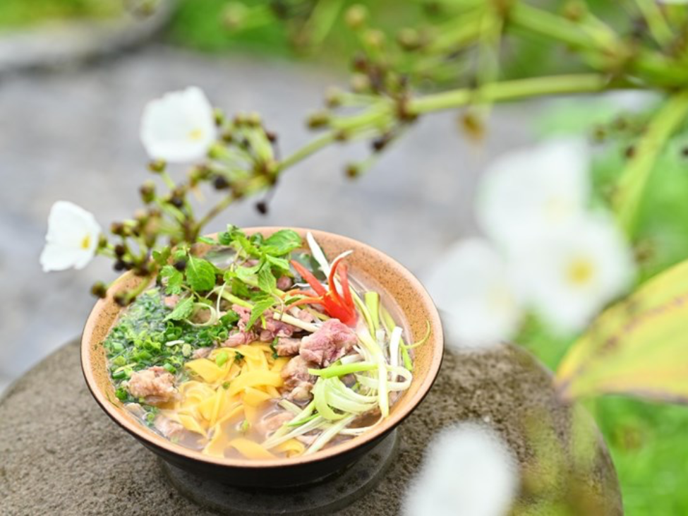 A bowl of Phở Ngô in Ha Giang with golden corn noodles and beef broth