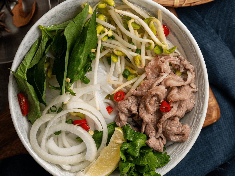 Step-by-step guide to customizing a bowl of pho with various toppings