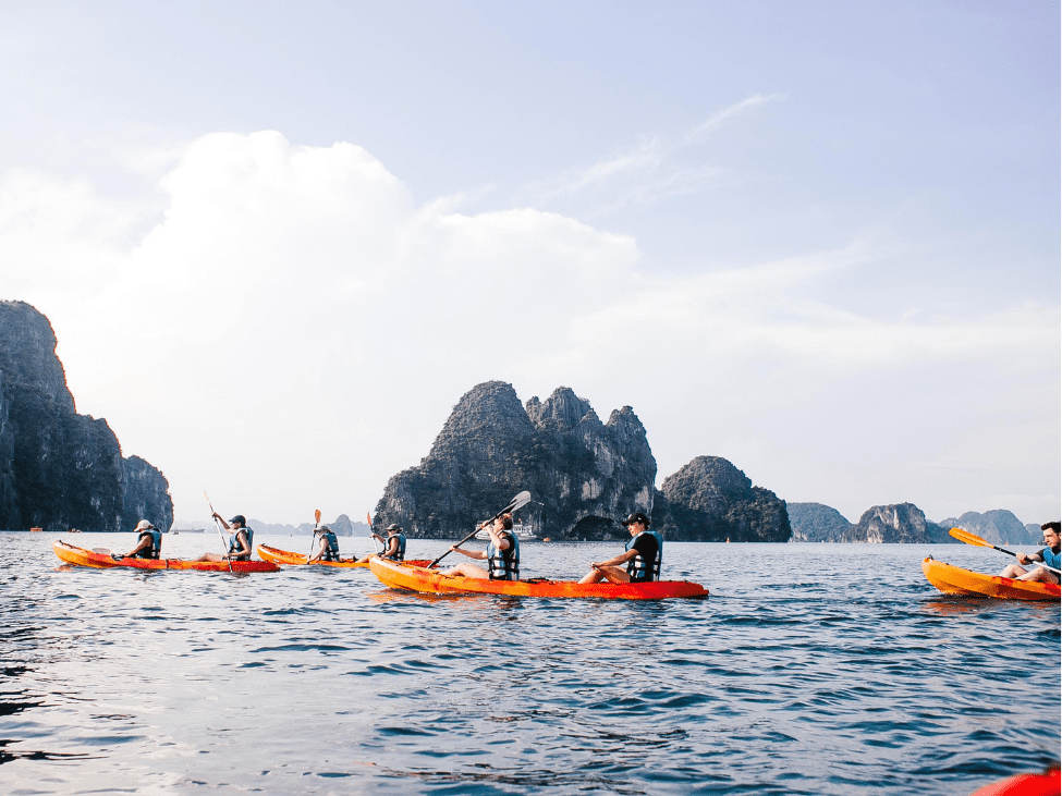 Family kayaking in Halong Bay, surrounded by limestone karsts.