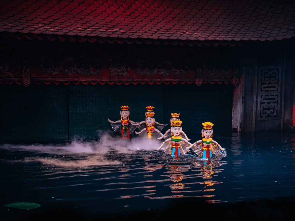 Family watching a water puppet show in Hanoi.