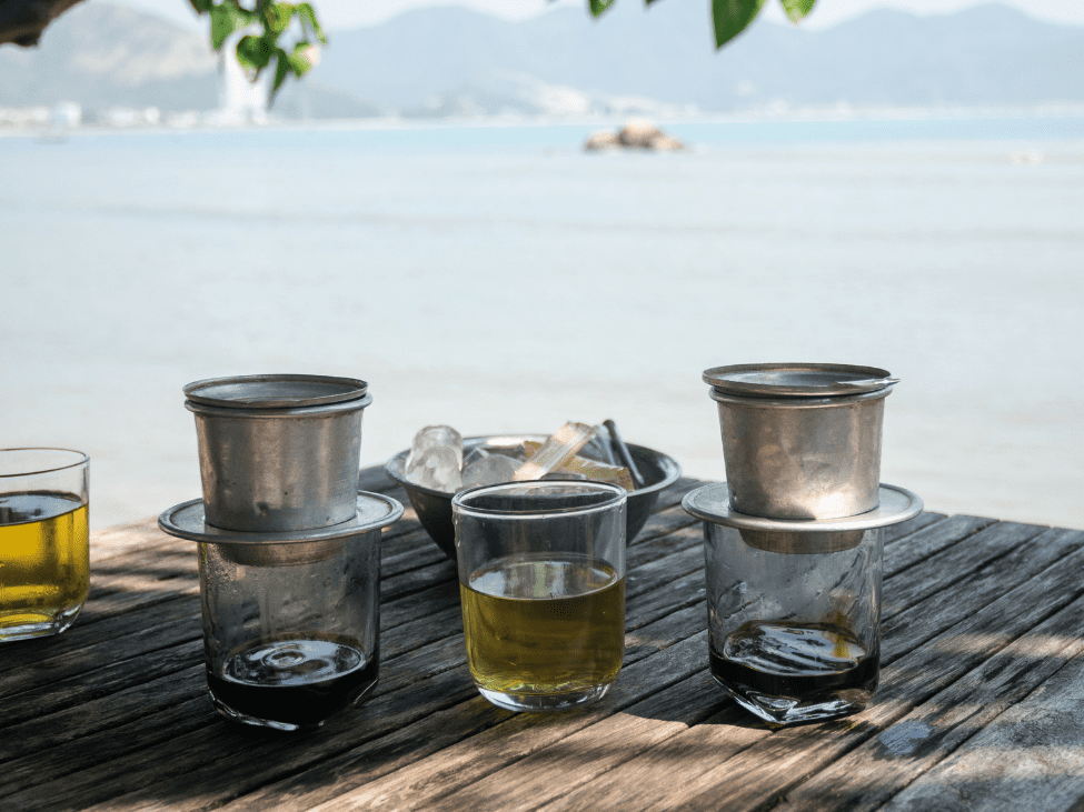 A cup of Vietnamese drip coffee served at a local café in Hoi An countryside, surrounded by greenery.