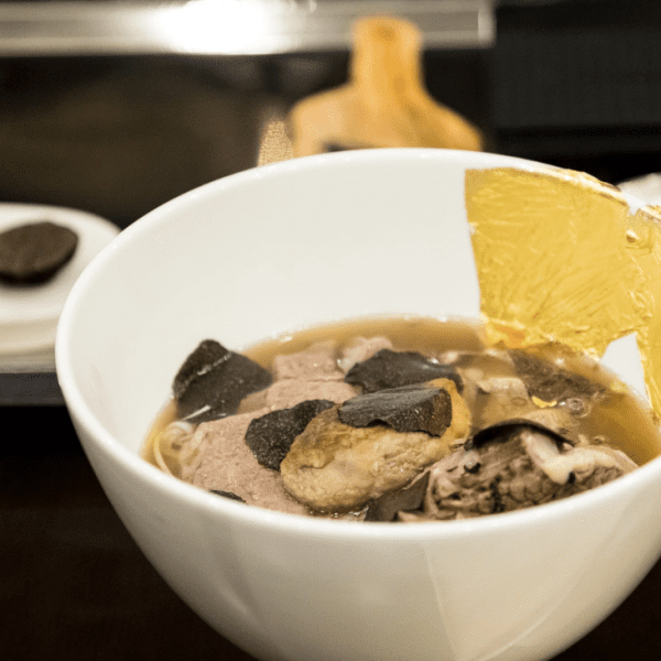 A bowl of “Phở King” at Landmark 81, featuring Wagyu beef, truffle shavings, foie gras, and gold leaf, served in an elegant setting.