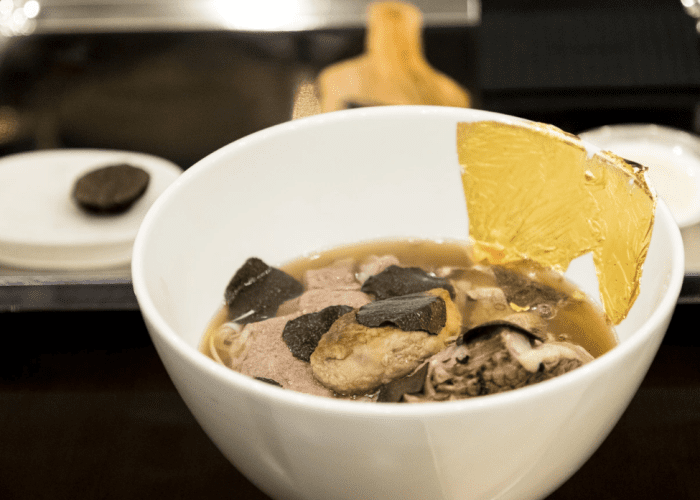 A bowl of “Phở King” at Landmark 81, featuring Wagyu beef, truffle shavings, foie gras, and gold leaf, served in an elegant setting.