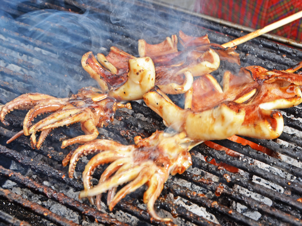 A dish of grilled squid with butter and garlic at Ốc , served alongside snails stir-fried with chili.