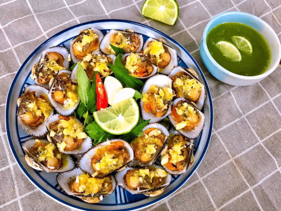 A dish of snails grilled with scallion oil at Ốc Thảo, served with grilled prawns and squid.